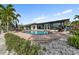 Beautiful pool with brick pavers, lush landscaping, and lounge chairs at 241 176Th Terrace E Dr, Redington Shores, FL 33708