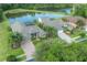 Aerial shot of homes with screened pools backing onto a tranquil pond, surrounded by lush trees at 27528 Water Ash Dr, Wesley Chapel, FL 33544