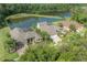 Aerial shot of homes with screened pools backing onto a tranquil pond, surrounded by lush trees at 27528 Water Ash Dr, Wesley Chapel, FL 33544