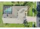 Top-down aerial view of a home with a screened pool, lush landscaping, and a brick driveway at 27528 Water Ash Dr, Wesley Chapel, FL 33544