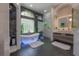 A luxurious bathroom with freestanding tub, decorative accents, and marble and glass shower at 27528 Water Ash Dr, Wesley Chapel, FL 33544