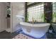 Bathroom with free standing tub, natural light, black marble accent wall, and access to the toilet room at 27528 Water Ash Dr, Wesley Chapel, FL 33544