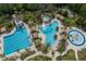 Aerial view showcasing the sparkling blue community pool with slide, spa, and splash pad at 27528 Water Ash Dr, Wesley Chapel, FL 33544