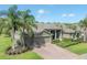 Beautiful home with a three-car garage, brick driveway, and lush landscaping, showcasing curb appeal at 27528 Water Ash Dr, Wesley Chapel, FL 33544