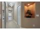 Neutral hallway with lit art niche with a potted bonsai tree and a view of the bathroom at 27528 Water Ash Dr, Wesley Chapel, FL 33544
