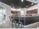 Kitchen with granite countertop, dark cabinets and stainless steel stools for seating at the breakfast bar at 27528 Water Ash Dr, Wesley Chapel, FL 33544