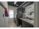 Modern laundry room with dark cabinets, front load washer/dryer, lighted mirror and stylish tile flooring at 27528 Water Ash Dr, Wesley Chapel, FL 33544
