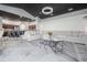 Open-concept living room boasts a modern light fixture, white L-shaped sofa and black marble flooring at 27528 Water Ash Dr, Wesley Chapel, FL 33544