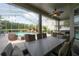 Spacious covered patio with an outdoor dining area and cozy lounge seating overlooking the screened pool at 27528 Water Ash Dr, Wesley Chapel, FL 33544