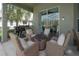 Covered patio area with comfortable seating, grill, and access to the screened pool, ideal for outdoor entertainment at 27528 Water Ash Dr, Wesley Chapel, FL 33544