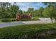 Entrance to The Club at Seven Oaks community featuring brick signage and manicured landscaping at 27528 Water Ash Dr, Wesley Chapel, FL 33544