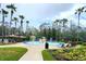 Fun splash pad area surrounded by palm trees, lounge chairs, and a well-manicured lawn at 27528 Water Ash Dr, Wesley Chapel, FL 33544