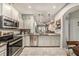 This open kitchen features stainless steel appliances, light cabinets, and granite countertops at 2844 Jacob Crossing Ln, Holiday, FL 34691