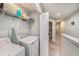 This laundry room has a washer, dryer, and shelving for storage at 2844 Jacob Crossing Ln, Holiday, FL 34691