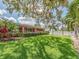 Expansive back yard featuring lush lawn, mature trees, and hedges, showcasing a tranquil outdoor space at 308 Cedar Ln, Largo, FL 33770