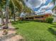 Manicured backyard with lush lawn and mature trees perfect for outdoor entertaining at 308 Cedar Ln, Largo, FL 33770