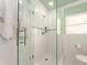 Bathroom with a modern glass shower enclosure, white tiled walls, and a dual shower head at 308 Cedar Ln, Largo, FL 33770