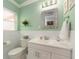 Fresh bathroom featuring a white vanity, stylish mirror, and ample natural light from the window at 308 Cedar Ln, Largo, FL 33770
