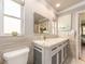 Bright bathroom with a marble countertop vanity, wall-mounted mirror, and abundant natural light at 308 Cedar Ln, Largo, FL 33770