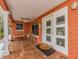 Welcoming front porch featuring tiled flooring, ample seating, and a decorative front door for a cozy entry at 308 Cedar Ln, Largo, FL 33770