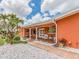 Inviting front porch with a tiled walkway, cozy seating, and vibrant plants adds curb appeal to this home at 308 Cedar Ln, Largo, FL 33770
