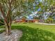 Well-maintained front yard, showcasing lush green lawn, mature trees, and inviting curb appeal at 308 Cedar Ln, Largo, FL 33770