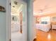 Hallway view of a bathroom with a white vanity and a bedroom with an inviting bed and bright light at 308 Cedar Ln, Largo, FL 33770
