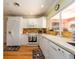 Eat-in kitchen featuring white cabinets, stainless steel appliances and tiled backsplash at 308 Cedar Ln, Largo, FL 33770