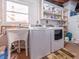 Functional laundry area with washer, dryer, utility sink, and shelving for organized storage at 308 Cedar Ln, Largo, FL 33770