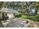Landscaped backyard featuring patio, manicured lawn, and mature trees at 3315 W Hawthorne Rd, Tampa, FL 33611