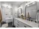 Bright bathroom with double vanity, marble counters, matte black fixtures, modern lighting, and separate tub at 3315 W Hawthorne Rd, Tampa, FL 33611