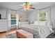 Bright bedroom with white furniture, hardwood floors, and natural light from large windows at 3315 W Hawthorne Rd, Tampa, FL 33611