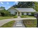 Inviting home exterior featuring a well-kept lawn, a paver walkway, and charming details such as a wreath on the front door at 3315 W Hawthorne Rd, Tampa, FL 33611