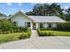 Inviting single-story home featuring lush green landscaping, a concrete driveway and walkway at 3315 W Hawthorne Rd, Tampa, FL 33611
