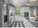 Stylish kitchen with stainless steel appliances, white cabinets, and black and white checkered flooring at 3315 W Hawthorne Rd, Tampa, FL 33611