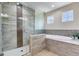 A luxurious bathroom featuring a glass-enclosed shower, a soaking tub and stylish tile flooring at 3503 W Price Ave, Tampa, FL 33611