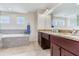 Elegant bathroom featuring a soaking tub, dual vanity with granite countertops and tile flooring at 3503 W Price Ave, Tampa, FL 33611