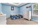 Bedroom featuring light blue walls, carpet, modern furniture, and a tray ceiling at 3503 W Price Ave, Tampa, FL 33611