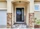 Close up of stylish front door with stone accents and 'Welcome Home' wreath at 3503 W Price Ave, Tampa, FL 33611