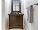 Traditional powder room with dark wood vanity, granite countertop, decorative mirror and towel rack at 3503 W Price Ave, Tampa, FL 33611