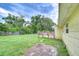 Spacious backyard featuring a well-maintained lawn, mature trees, wood fence, and a patio area for outdoor enjoyment at 40019 Pretty Redbird Rd, Zephyrhills, FL 33540