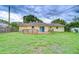 Exterior view of the home, showcasing a wooden deck, sliding glass doors, and a well-maintained lawn at 40019 Pretty Redbird Rd, Zephyrhills, FL 33540