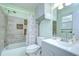 Bathroom features a shower-tub combo with stylish tilework and updated vanity at 40019 Pretty Redbird Rd, Zephyrhills, FL 33540