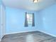 Cozy blue bedroom with hardwood floors and a window offering natural light at 40019 Pretty Redbird Rd, Zephyrhills, FL 33540