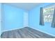 Cozy blue bedroom with hardwood floors and a window offering natural light at 40019 Pretty Redbird Rd, Zephyrhills, FL 33540