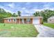 Charming brick home featuring a well-maintained lawn and a one-car garage at 40019 Pretty Redbird Rd, Zephyrhills, FL 33540