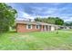 Traditional brick home featuring clean lines, white trim, and a well-kept lawn at 40019 Pretty Redbird Rd, Zephyrhills, FL 33540