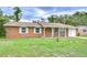 Well-maintained brick house with a manicured front yard, traditional windows, and attached garage at 40019 Pretty Redbird Rd, Zephyrhills, FL 33540