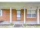Covered front porch featuring brick columns and a decorative address number at 40019 Pretty Redbird Rd, Zephyrhills, FL 33540