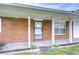 Charming brick home featuring a covered front porch with classic white columns and well-maintained landscaping at 40019 Pretty Redbird Rd, Zephyrhills, FL 33540